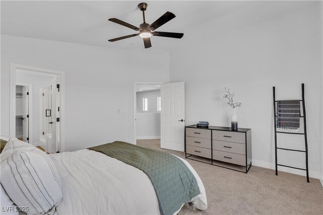 bedroom featuring light colored carpet, ceiling fan, and baseboards