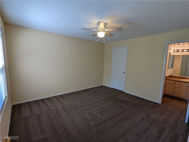 555 E Silverado Ranch Blvd Unit 2147, Las Vegas, NV 89183 - unfurnished bedroom with dark colored carpet, baseboards, connected bathroom, and a ceiling fan
