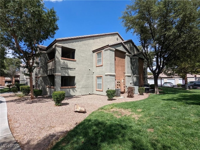 555 E Silverado Ranch Blvd Unit 2147, Las Vegas, NV 89183 - view of side of home with central AC, stucco siding, and a lawn