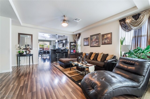 184 Cullerton St, Las Vegas, NV 89148 - living area with wood finished floors, a ceiling fan, a tray ceiling, and baseboards
