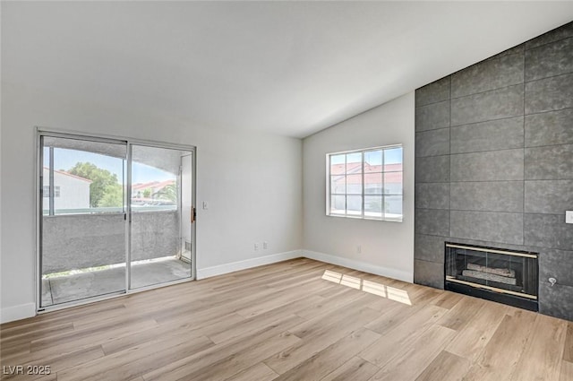 2725 S Nellis Blvd Unit 2036, Las Vegas, NV 89121 - unfurnished living room with vaulted ceiling, wood finished floors, a tile fireplace, and baseboards
