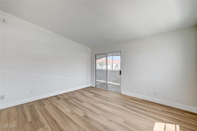 2725 S Nellis Blvd Unit 2036, Las Vegas, NV 89121 - spare room featuring baseboards, light wood-style floors, and vaulted ceiling