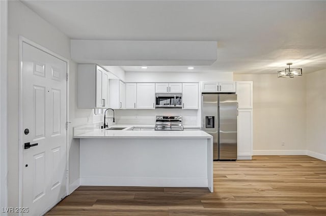 2725 S Nellis Blvd Unit 2036, Las Vegas, NV 89121 - kitchen featuring appliances with stainless steel finishes, a sink, baseboards, light countertops, and light wood-type flooring
