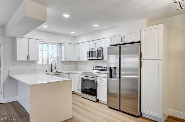 2725 S Nellis Blvd Unit 2036, Las Vegas, NV 89121 - kitchen with stainless steel appliances, a sink, a peninsula, baseboards, and white cabinets