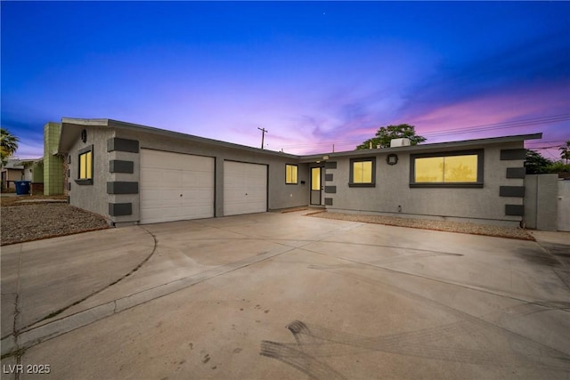 single story home featuring an attached garage, driveway, and stucco siding