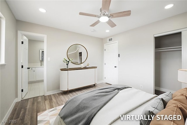 bedroom with wood finished floors, recessed lighting, a closet, baseboards, and ensuite bath