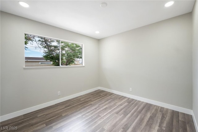 empty room featuring wood finished floors, baseboards, and recessed lighting