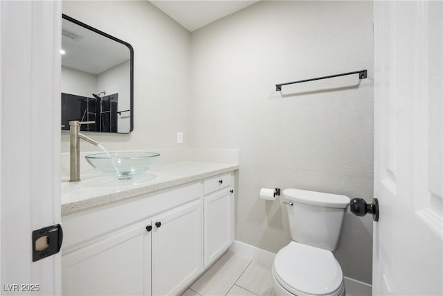 bathroom with baseboards, toilet, vanity, and tile patterned floors