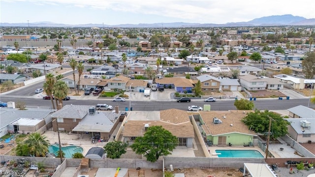 aerial view of residential area with a pool and a mountainous background