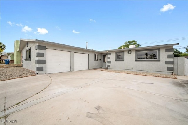 view of front of property with an attached garage, driveway, and stucco siding