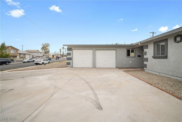garage featuring concrete driveway and a residential view