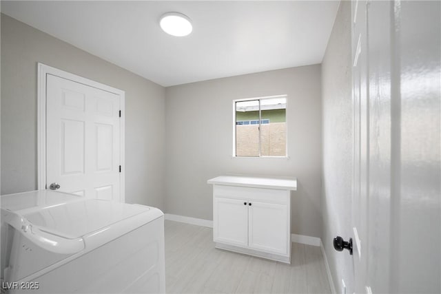 laundry area featuring baseboards, cabinet space, and independent washer and dryer