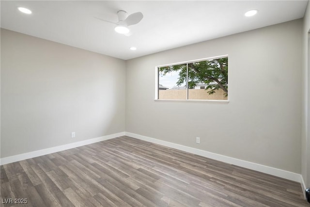 unfurnished room with wood finished floors, baseboards, and recessed lighting