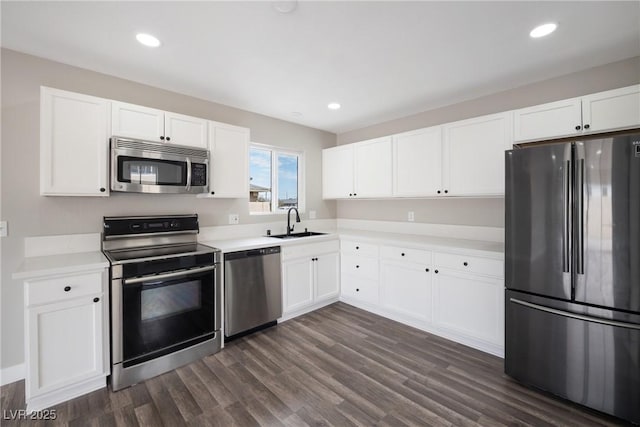 kitchen with appliances with stainless steel finishes, a sink, white cabinetry, light countertops, and recessed lighting