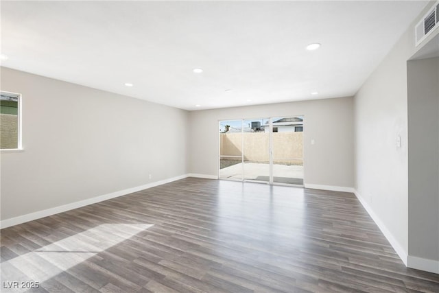 empty room featuring wood finished floors, baseboards, and recessed lighting