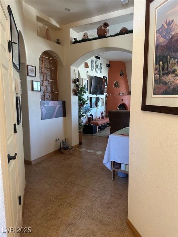 3551 Sagebrush Ave, Pahrump, NV 89048 - hallway with arched walkways, tile patterned floors, and baseboards