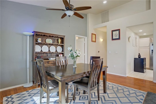 2325 Windmill Pkwy Unit 321, Henderson, NV 89074 - dining space featuring ceiling fan, light wood-style flooring, a high ceiling, baseboards, and recessed lighting