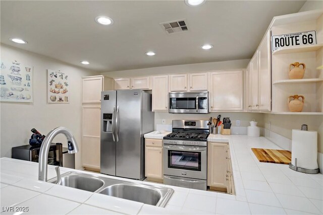 2325 Windmill Pkwy Unit 321, Henderson, NV 89074 - kitchen with stainless steel appliances, tile countertops, recessed lighting, open shelves, and a sink