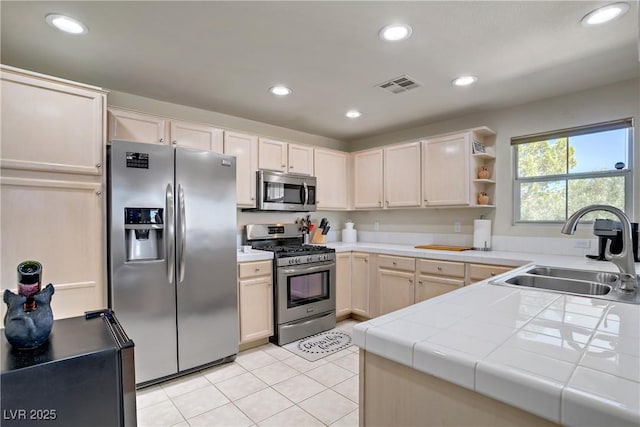 2325 Windmill Pkwy Unit 321, Henderson, NV 89074 - kitchen featuring stainless steel appliances, a sink, tile counters, light tile patterned flooring, and open shelves