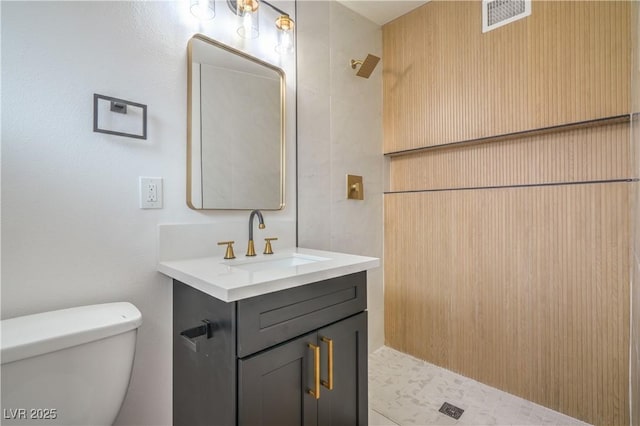 bathroom with toilet, vanity, and a shower
