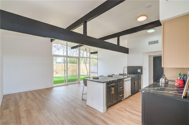 kitchen featuring dishwasher, a sink, high vaulted ceiling, beamed ceiling, and dark countertops