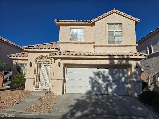 mediterranean / spanish-style home with a garage, stucco siding, a tiled roof, and driveway