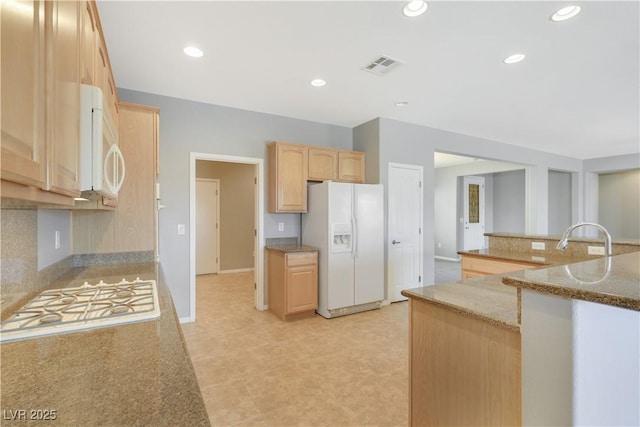 2183 Waterton Rivers Dr, Henderson, NV 89044 - kitchen with white appliances, light brown cabinetry, decorative backsplash, light stone counters, and recessed lighting