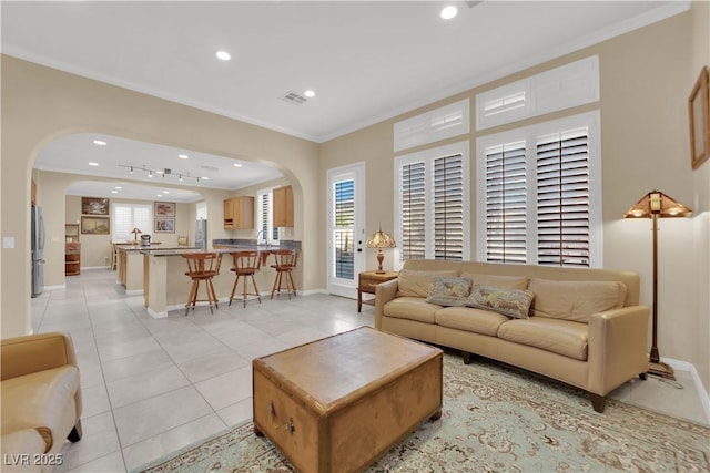 7183 Majestic Bluff Pl, Las Vegas, NV 89113 - living room featuring arched walkways, ornamental molding, recessed lighting, light tile patterned floors, and baseboards