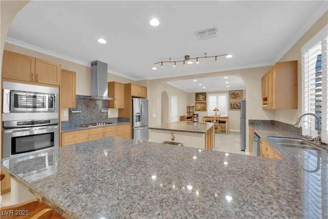 7183 Majestic Bluff Pl, Las Vegas, NV 89113 - kitchen with stainless steel appliances, a sink, arched walkways, wall chimney range hood, and a kitchen island
