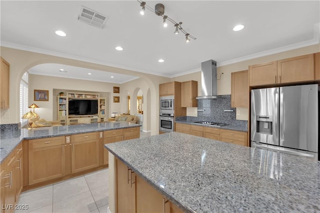 7183 Majestic Bluff Pl, Las Vegas, NV 89113 - kitchen with appliances with stainless steel finishes, arched walkways, wall chimney range hood, tasteful backsplash, and ornamental molding