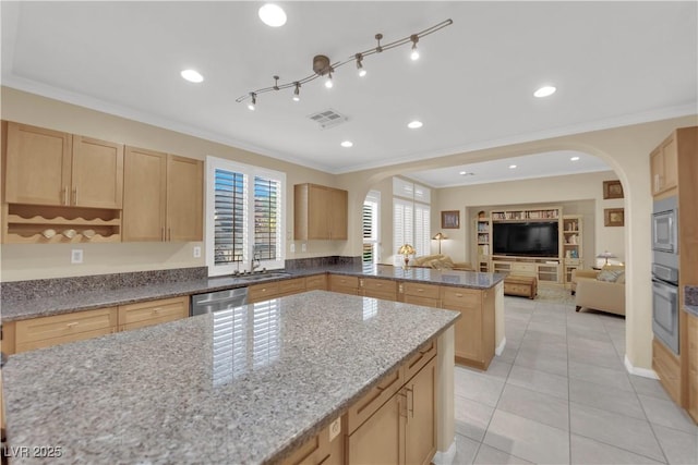 7183 Majestic Bluff Pl, Las Vegas, NV 89113 - kitchen with arched walkways, appliances with stainless steel finishes, light brown cabinetry, ornamental molding, and open floor plan
