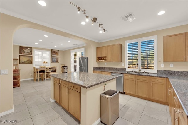 7183 Majestic Bluff Pl, Las Vegas, NV 89113 - kitchen with stainless steel appliances, arched walkways, crown molding, a sink, and light tile patterned floors