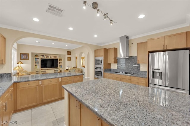 7183 Majestic Bluff Pl, Las Vegas, NV 89113 - kitchen featuring appliances with stainless steel finishes, arched walkways, wall chimney range hood, backsplash, and ornamental molding