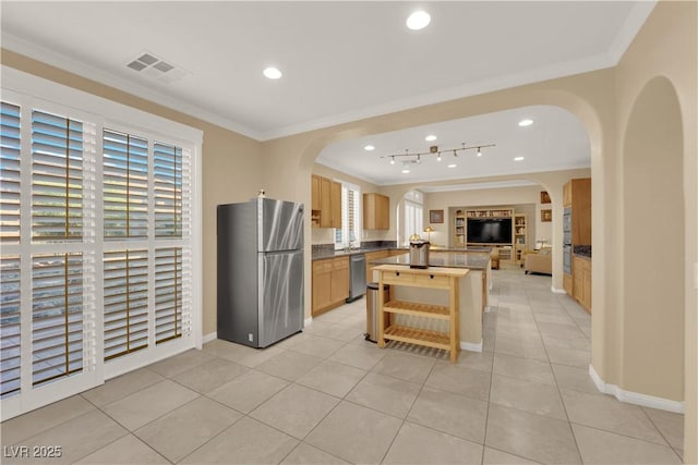 7183 Majestic Bluff Pl, Las Vegas, NV 89113 - kitchen with appliances with stainless steel finishes, ornamental molding, arched walkways, light tile patterned flooring, and light brown cabinets