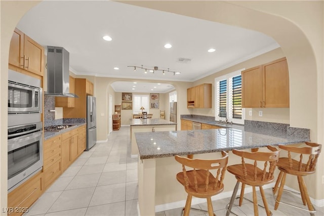 7183 Majestic Bluff Pl, Las Vegas, NV 89113 - kitchen featuring stainless steel appliances, wall chimney exhaust hood, arched walkways, a sink, and crown molding