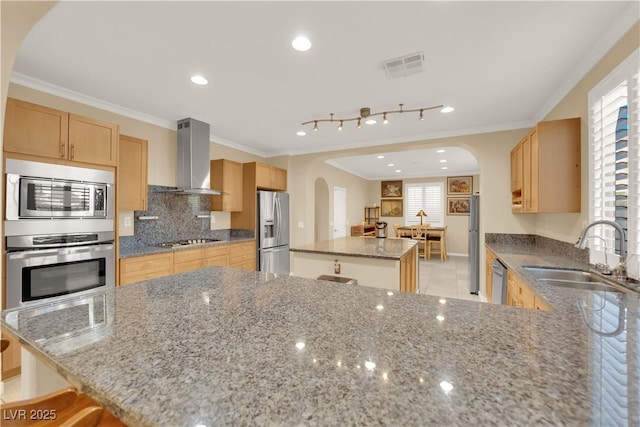 7183 Majestic Bluff Pl, Las Vegas, NV 89113 - kitchen with stainless steel appliances, a sink, arched walkways, wall chimney exhaust hood, and a center island