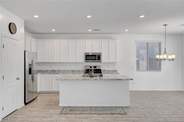 10735 Galveston Bay St, Las Vegas, NV 89179 - kitchen with stainless steel appliances, wood tiled floors, light stone countertops, and recessed lighting