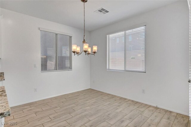 10735 Galveston Bay St, Las Vegas, NV 89179 - empty room featuring a chandelier, light wood finished floors, and baseboards