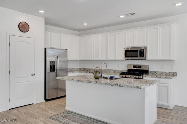 10735 Galveston Bay St, Las Vegas, NV 89179 - kitchen with appliances with stainless steel finishes, wood tiled floors, white cabinetry, and recessed lighting