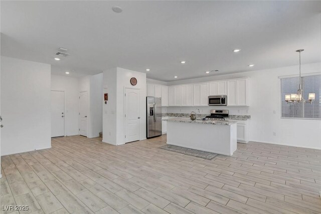 10735 Galveston Bay St, Las Vegas, NV 89179 - kitchen featuring appliances with stainless steel finishes, a chandelier, open floor plan, white cabinets, and recessed lighting