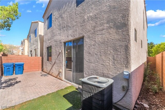 9753 Villa Lorena Ave, Las Vegas, NV 89147 - rear view of property with stucco siding, central AC unit, a fenced backyard, and a patio