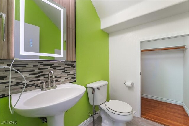 9753 Villa Lorena Ave, Las Vegas, NV 89147 - bathroom featuring backsplash, toilet, a sink, and baseboards