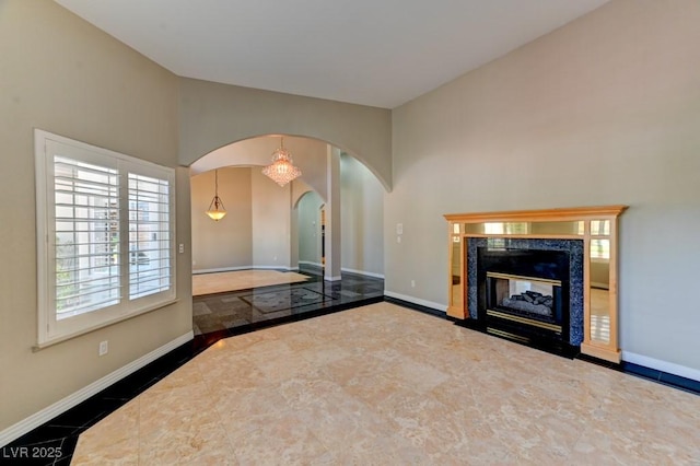 7540 Crystal Cave Dr, Las Vegas, NV 89117 - unfurnished living room featuring arched walkways, inlaid floor details, and a premium fireplace