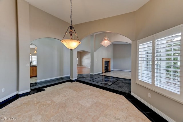7540 Crystal Cave Dr, Las Vegas, NV 89117 - interior space with arched walkways, inlaid floor details, high vaulted ceiling, and dark tile patterned floors