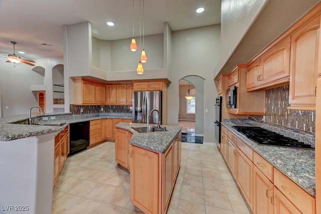 7540 Crystal Cave Dr, Las Vegas, NV 89117 - kitchen with black appliances, an island with sink, arched walkways, tasteful backsplash, and a ceiling fan