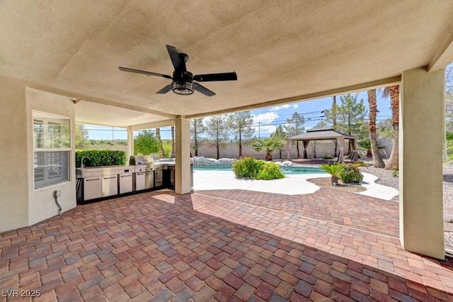 7540 Crystal Cave Dr, Las Vegas, NV 89117 - fenced backyard featuring a gazebo, exterior kitchen, ceiling fan, an outdoor pool, and a patio