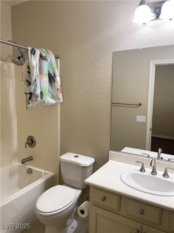 full bathroom with  shower combination, a textured wall, vanity, and toilet