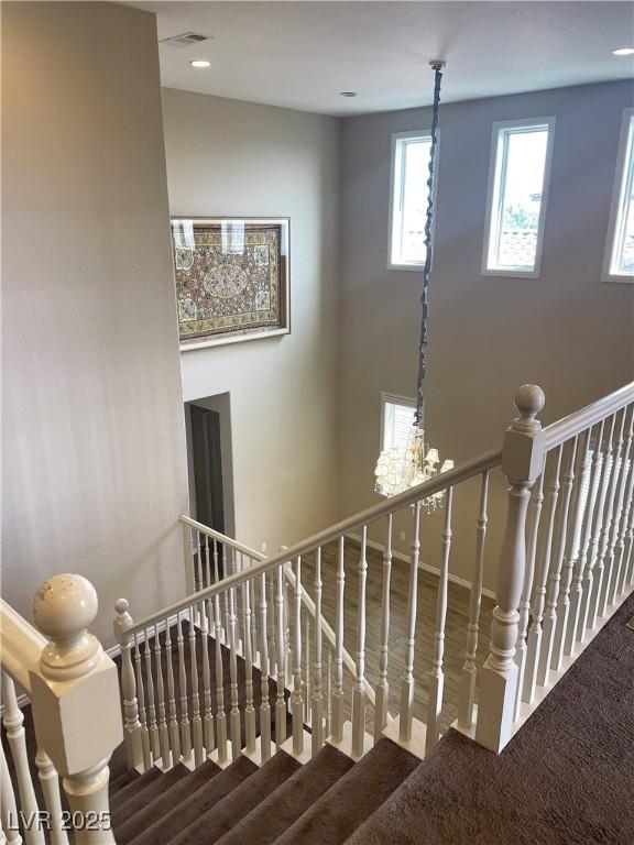 staircase with carpet flooring and a towering ceiling