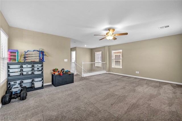 carpeted spare room with plenty of natural light, ceiling fan, and baseboards