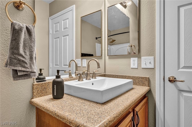 bathroom with a textured wall and vanity